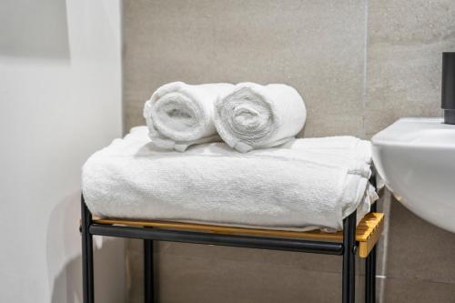 a pile of towels on a towel rack in a bathroom at Penthouse Apartment in Central Leeds Near Train Station Free WiFi Free Parking in Central Station