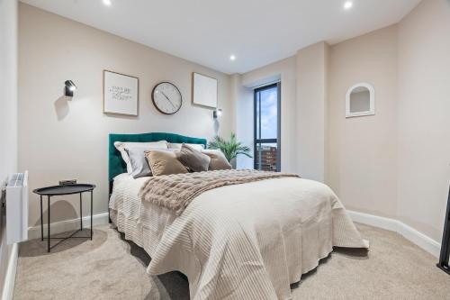 a bedroom with a bed and a clock on the wall at Penthouse Apartment in Central Leeds Near Train Station Free WiFi Free Parking in Central Station