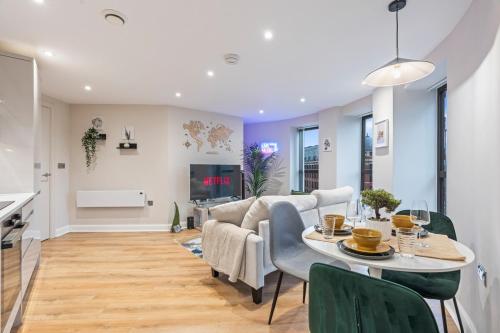 a dining room and living room with a table and chairs at Penthouse Apartment in Central Leeds Near Train Station Free WiFi Free Parking in Central Station
