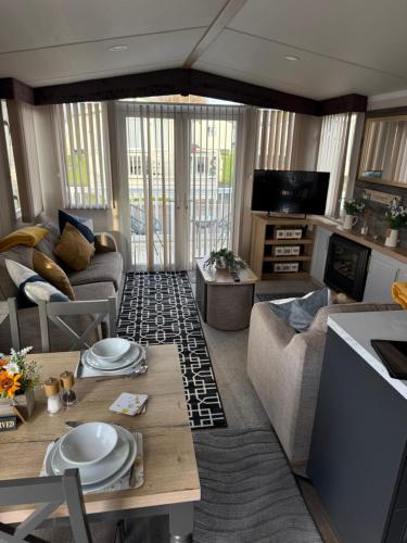 a living room with a couch and a table at Mimosa holiday home in Little Clacton