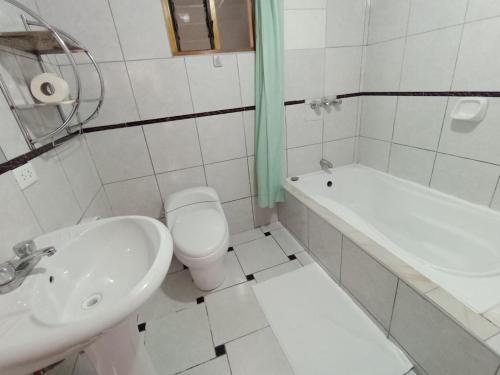 a bathroom with a sink and a toilet and a tub at Huilka Mayu in Urubamba