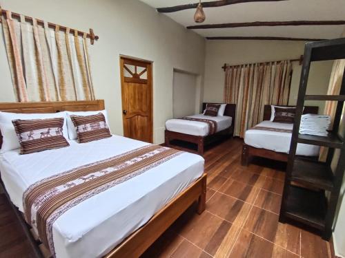 a bedroom with two beds and a ladder at Huilka Mayu in Urubamba