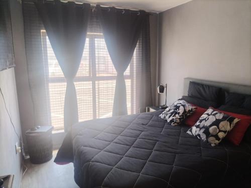 a bedroom with a large bed and a window at Beach Vibes Villa in Cape Town