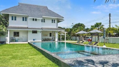 a villa with a swimming pool in front of a house at Khaolak 16 meters-Pool Villa with 3 bedrooms 3 bathrooms-Kokotel Montana Hotel in Khao Lak