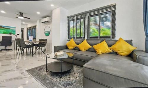 a living room with a gray couch and yellow pillows at Khaolak 16 meters-Pool Villa with 3 bedrooms 3 bathrooms-Kokotel Montana Hotel in Khao Lak