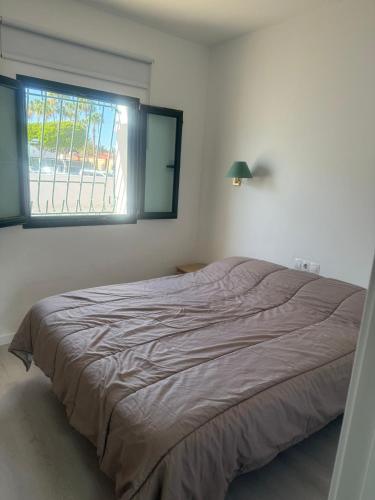 ein Bett in einem Schlafzimmer mit Fenster in der Unterkunft Europe sun bungalow 2 bedrooms in Maspalomas