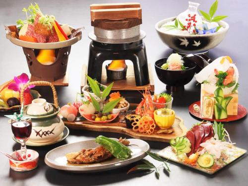 a table with plates of food and a coffee maker at Oyado Yunosato in Shirakawa