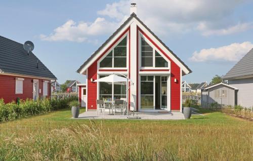 une maison rouge avec un toit avec une table et un parasol dans l'établissement Haus Patricia, à Wandlitz