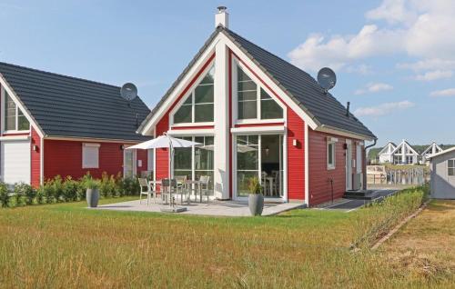 une maison rouge avec un patio devant dans l'établissement Haus Patricia, à Wandlitz