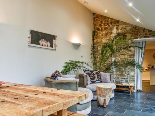 Honeysuckle Cottage في High Bickington: غرفة معيشة مع طاولة وكراسي خشبية