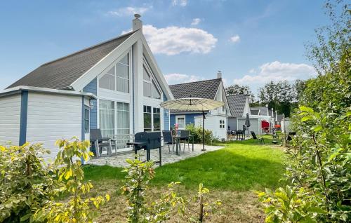 una casa bianca con patio e ombrellone di Villa Kunterbunt a Wandlitz