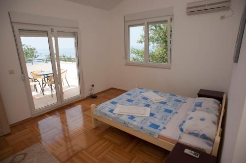 a bedroom with a bed in a room with a balcony at Apartments Villa Simonovic in Petrovac na Moru