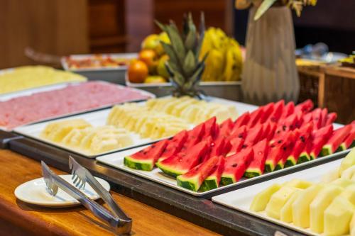 a buffet with watermelons and other foods on trays at Gran Villagio Hotel SP by Castelo Itaipava in Sao Paulo