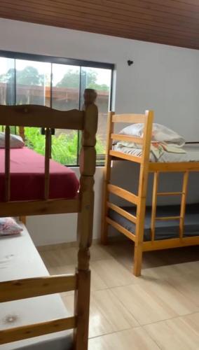 Un dormitorio con dos literas y una ventana. en Pousada Mizuyama, en Praia do Rosa