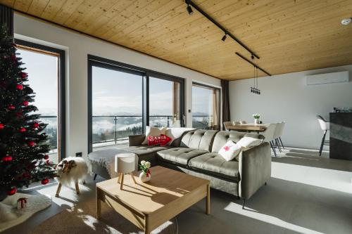 een woonkamer met een kerstboom en een bank bij Tatres Bachledówka in Czerwienne