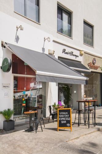 Un restaurante con mesas y sillas frente a un edificio. en Urban Condo 33 with Balcony - 2 Bdr, en Nicosia