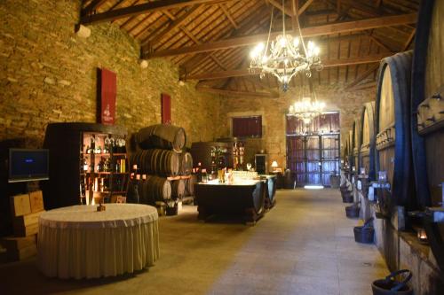 Una habitación con mesas y una lámpara de araña en un edificio. en Refúgio Rústico - Exclusivo, en Favaios