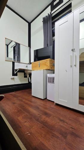 a room with white cabinets and a wooden floor at Ozi Inn Backpackers - Perth -Valid International Passport Required in Perth