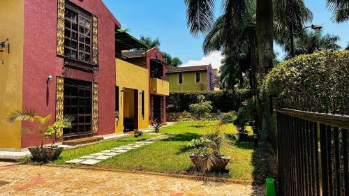 カンパラにあるMaison Princetonのヤシの木と庭のある一群の家