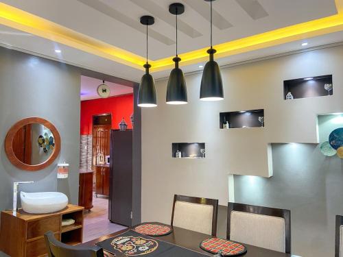 a dining room with a table and chairs and lights at Maison Princeton in Kampala