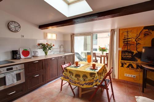 une cuisine avec une table et une horloge au mur dans l'établissement Studio Panier 1930, à Marseille