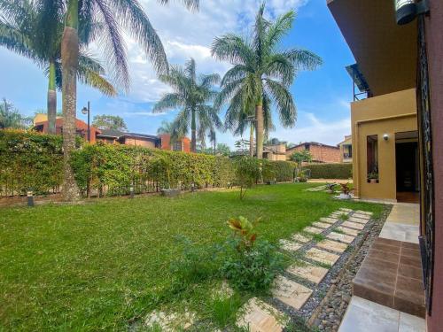 カンパラにあるMaison Princetonのヤシの木と家の庭