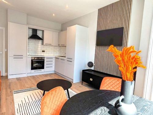 a kitchen and dining room with a table and chairs at Stunning Modern Apartment Sleeps 4 - 6 Min walk from Golden Beaches-Free Parking in Bournemouth