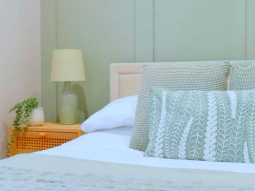 a white bed with a blue pillow and a lamp at Stunning Apartment-6 Minute walk from Beach-Free Parking in Bournemouth