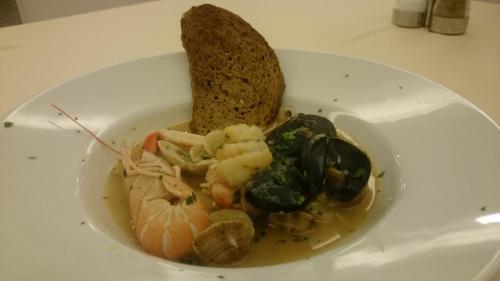 a white plate with a bowl of food on a table at Hotel Bristol in Lignano Sabbiadoro