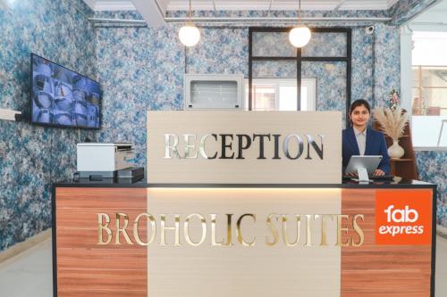 a woman standing behind a reception desk in a store at FabHotel Broholic Suites - Nr US Consulate, Financial District in Hyderabad
