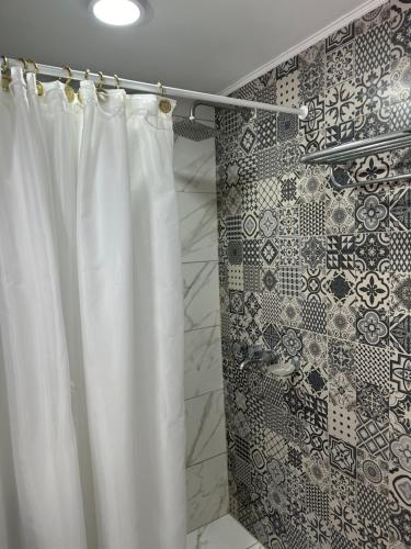een douche met een wit douchegordijn in een badkamer bij Bilbao 44 in Santa Clara del Mar