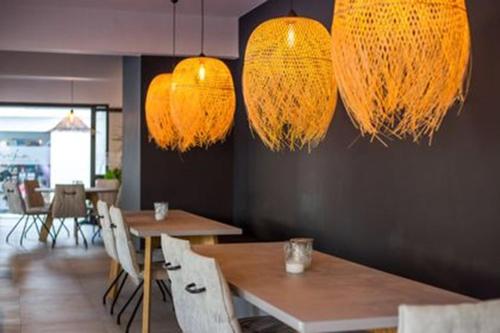 een restaurant met tafels, stoelen en verlichting bij Anika Studios Faliraki in Faliraki