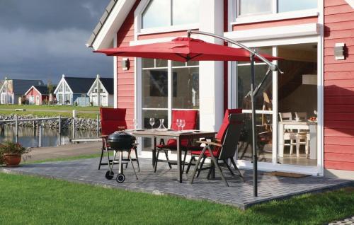 a patio with a table and chairs and an umbrella at Haus zum maritimen Blick in Wandlitz