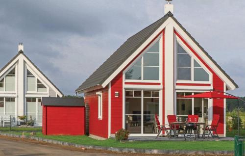 a red and white house with a table and chairs at Haus zum maritimen Blick in Wandlitz