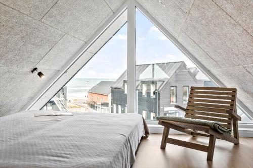 1 dormitorio con 1 cama y 1 silla frente a una ventana en 794-Thisted-Havstokken-26-1, en Thisted