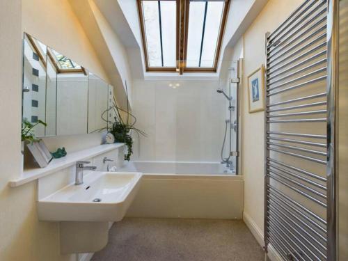 um banheiro com pia e banheira em Turfhill House em New Deer