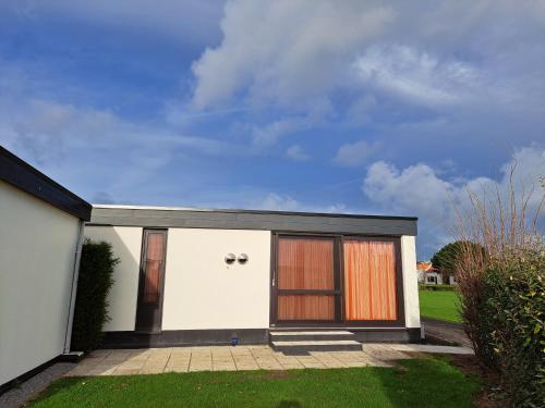 a white house with two large doors on it at Jonckershof Middelkerke bungalow 26 in Middelkerke