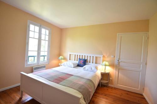 Ένα ή περισσότερα κρεβάτια σε δωμάτιο στο Hossegor Charmante villa avec piscine, jardin et dépendance pour 15 personnes.