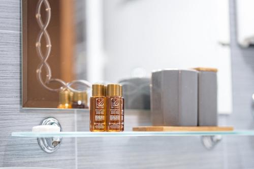 a shelf with two bottles of essential oils and books at 400m from Ski lift Belvedere Apartment - SPA - Free parking in Bansko