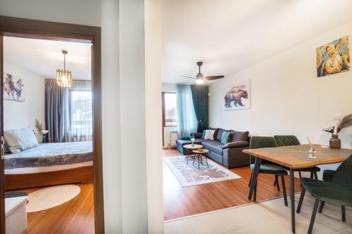 a living room and a bedroom with a bed and a table at 400m from Ski lift Belvedere Apartment - SPA - Free parking in Bansko