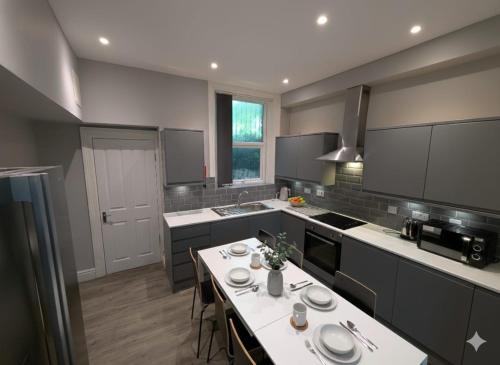 a kitchen with a table with plates on it at Summerhill Sunderland Business Stay 6 Private Ensuite Rooms in Sunderland