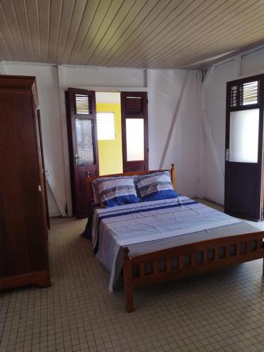 a bedroom with a bed in a room with windows at la bella vita in Port-Louis