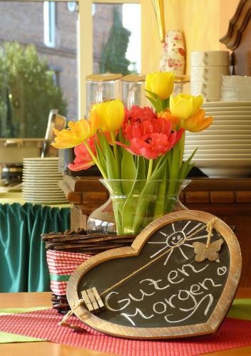 a table with a sign with a vase of flowers at Landhaus Bolzum in Sehnde