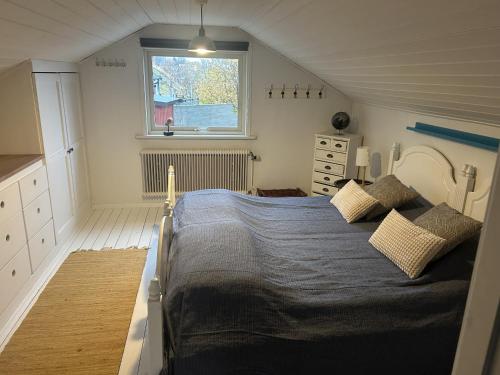 a bedroom with a large bed and a window at Lovely view & walking distance to the beach SE09150 in Svanesund