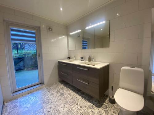 a bathroom with a sink and a toilet and a mirror at Lovely view & walking distance to the beach SE09150 in Svanesund