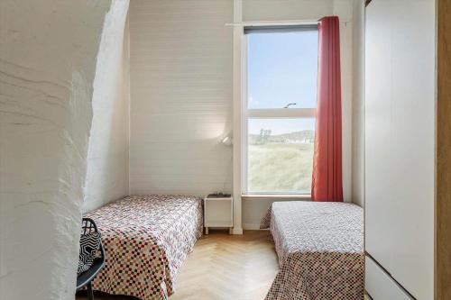 a small room with two beds and a window at 302-Snedsted-Klitfogedvej-7 in Snedsted