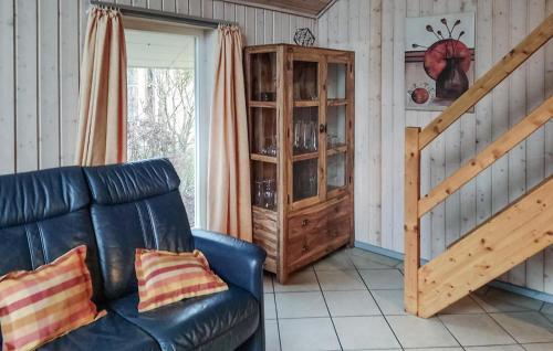 a living room with a black leather couch and a staircase at Amazing Home In Rechlin With Wifi in Rechlin