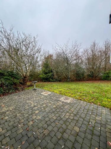 a stone walkway in a park with a field at Le Relais d'Hubert in Saint-Hubert