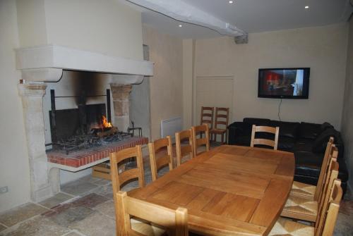une salle à manger avec une table et une cheminée dans l'établissement Pavillon Saint-Vincent, à Irancy