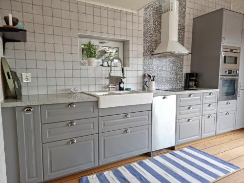 a kitchen with white cabinets and a sink at Modern Cottage with Sea View in Svanesund SE09151 in Svanesund